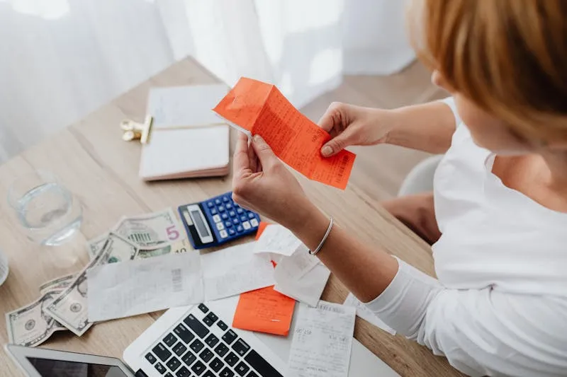 Business owner planning budget with calculator and laptop