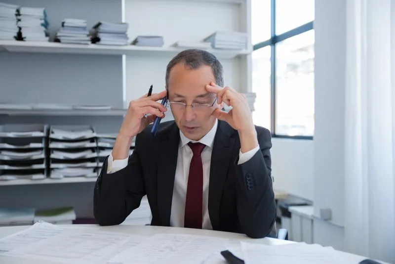 Busy business owner weighing a decision at a desk