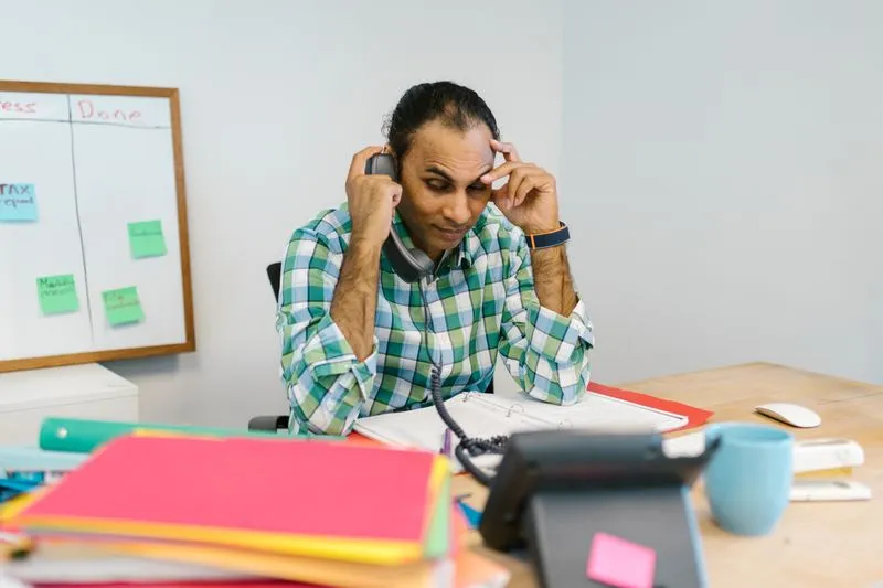Busy business owner managing multiple tasks at a desk