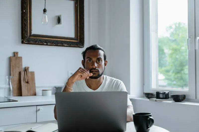 Person thinking with laptop open